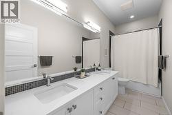 Full bath featuring double vanity, light tile patterned flooring, and shower / bath combo - 