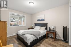 Suite Bedroom with wood finished floors and baseboard heating - 