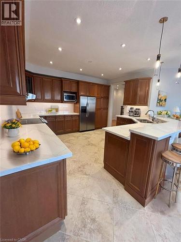 Kitchen featuring a breakfast bar area, stainless steel appliances, light stone countertops, recessed lighting, and pendant lighting - 93 Tremaine Drive, Kitchener, ON - Indoor Photo Showing Kitchen