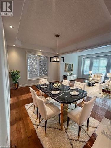 Dining area featuring a tray ceiling, recessed lighting, hardwood / wood-style floors, a chandelier, and healthy amount of natural light - 93 Tremaine Drive, Kitchener, ON - Indoor Photo Showing Dining Room