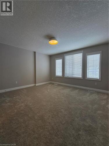 Carpeted spare room with baseboards and a textured ceiling - 93 Tremaine Drive, Kitchener, ON - Indoor Photo Showing Other Room