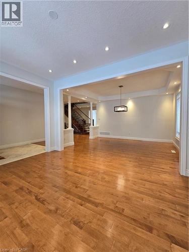Unfurnished living room with light wood-style floors, stairs, a textured ceiling, and recessed lighting - 93 Tremaine Drive, Kitchener, ON - Indoor Photo Showing Other Room