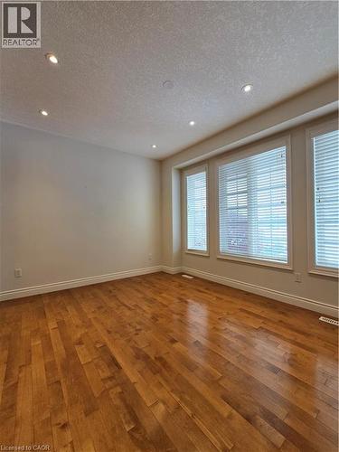 Spare room featuring wood-type flooring, recessed lighting, and a textured ceiling - 93 Tremaine Drive, Kitchener, ON - Indoor Photo Showing Other Room