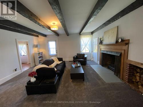 Original beamed ceilings throughout main level - 644 County 10 Road, Prince Edward County (Hallowell Ward), ON - Indoor Photo Showing Living Room With Fireplace
