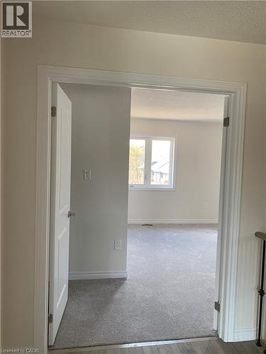 Hallway featuring carpet, a textured ceiling, and wood finished floors - 49 Eberhardt Drive, Wasaga Beach, ON - Indoor Photo Showing Other Room