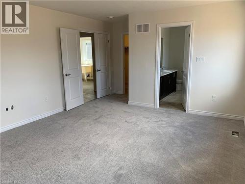 Unfurnished bedroom featuring light carpet and connected bathroom - 49 Eberhardt Drive, Wasaga Beach, ON - Indoor Photo Showing Other Room