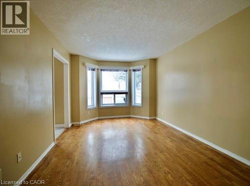 Unfurnished room with a textured ceiling and wood finished floors - 109 Beechmanor Crescent, Kitchener, ON - Indoor Photo Showing Other Room
