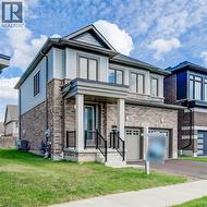 View of front of house with a front lawn, a porch, asphalt driveway, and an attached garage - 