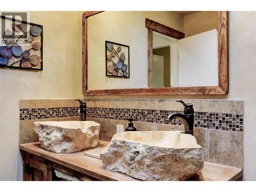 Indonesian stone sinks and wood vanity installed during 2016 bathroom reno - 391 Braeloch Road, Kelowna, BC - Indoor Photo Showing Bathroom
