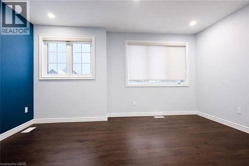 Empty room with dark wood-style floors and recessed lighting - 127 Elmbank Trail Unit# Upper, Kitchener, ON - Indoor Photo Showing Other Room