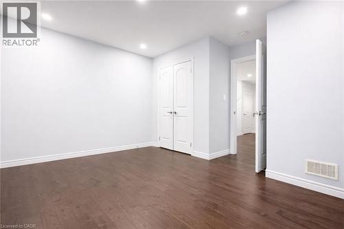 Unfurnished bedroom with dark wood finished floors, recessed lighting, and a closet - 127 Elmbank Trail Unit# Upper, Kitchener, ON - Indoor Photo Showing Other Room