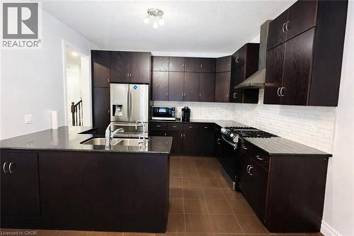 Kitchen with dark brown cabinets, appliances with stainless steel finishes, wall chimney exhaust hood, decorative backsplash, and dark stone countertops - 127 Elmbank Trail Unit# Upper, Kitchener, ON - Indoor Photo Showing Kitchen With Double Sink With Upgraded Kitchen