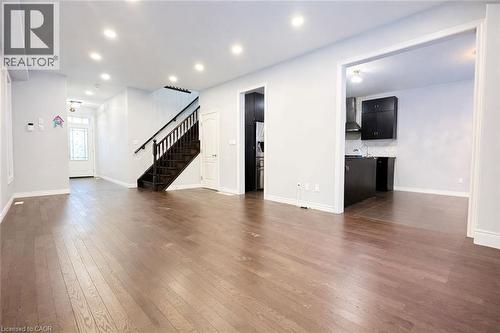 Unfurnished living room with stairs, dark wood-style floors, and recessed lighting - 127 Elmbank Trail Unit# Upper, Kitchener, ON - Indoor