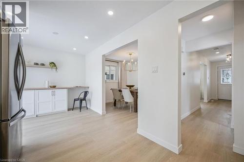 Kitchen with freestanding refrigerator, light wood-type flooring, open shelves, white cabinets, and recessed lighting - 21 Forest Glen Court, Kitchener, ON - Indoor