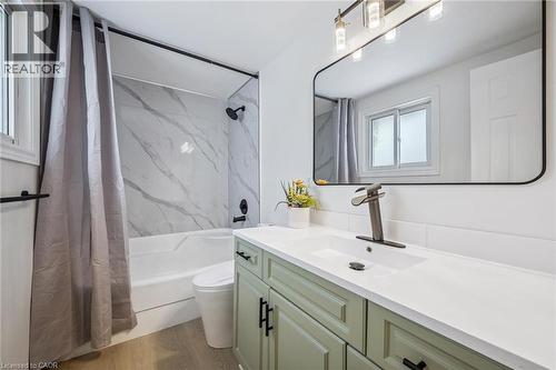 Full bath with shower / bath combo with shower curtain, vanity, and light wood-style flooring - 21 Forest Glen Court, Kitchener, ON - Indoor Photo Showing Bathroom