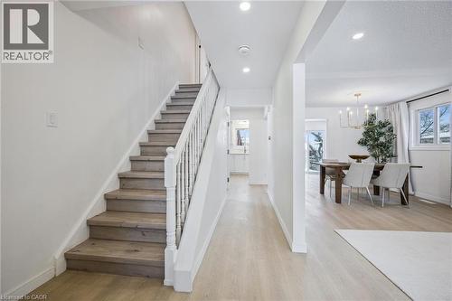 Stairs with wood finished floors, a chandelier, and recessed lighting - 21 Forest Glen Court, Kitchener, ON - Indoor Photo Showing Other Room
