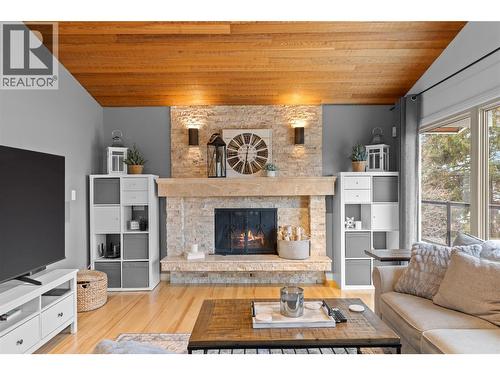Beautiful stone fireplace in living room - 11609 Upper Summit Drive, Coldstream, BC - Indoor Photo Showing Living Room With Fireplace