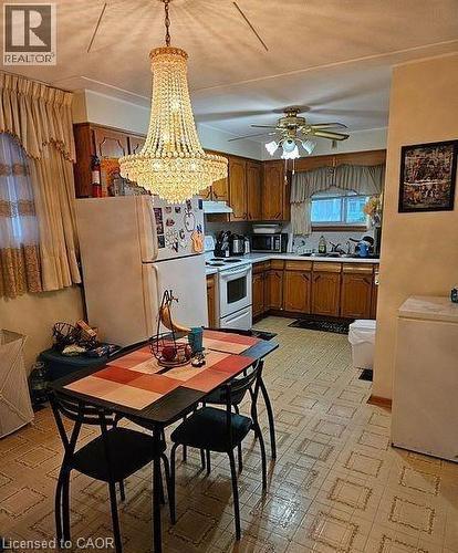 Kitchen with brown cabinets, white appliances, a chandelier, light countertops, and pendant lighting - 197 Craigroyston Road, Hamilton, ON - Indoor
