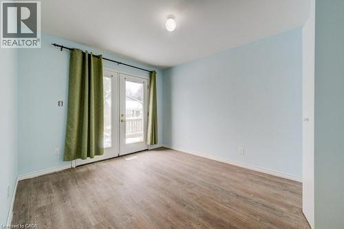 Empty room featuring french doors and wood finished floors - 33 Garland Crescent, London, ON - Indoor Photo Showing Other Room