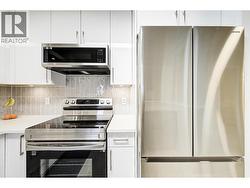 Beautifully updated kitchen with stainless steel appliances and quartz counters - 