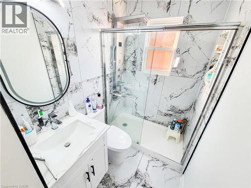 Bathroom with vanity, tile walls, a marble finish shower, and light marble finish flooring - 773 Queensdale Avenue E, Hamilton, ON - Indoor Photo Showing Bathroom