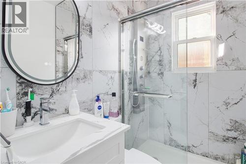 Bathroom with vanity, a marble finish shower, and tile walls - 773 Queensdale Avenue E, Hamilton, ON - Indoor Photo Showing Bathroom