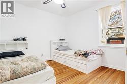 Bedroom with light wood finished floors and a ceiling fan - 