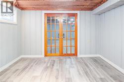 Unfurnished room featuring wood ceiling, light wood-style flooring, and french doors - 