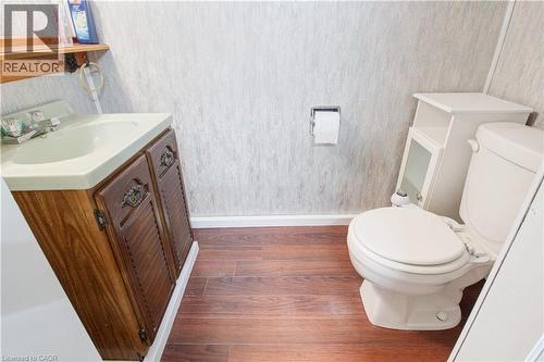 Bathroom featuring vanity, dark wood finished floors, and wallpapered walls - 773 Queensdale Avenue E, Hamilton, ON - Indoor Photo Showing Bathroom