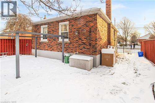 View of snow covered exterior with brick siding and a chimney - 773 Queensdale Avenue E, Hamilton, ON - Outdoor