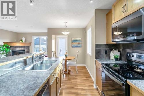 37 Silverado Saddle Avenue Sw, Calgary, AB - Indoor Photo Showing Kitchen With Fireplace With Double Sink With Upgraded Kitchen