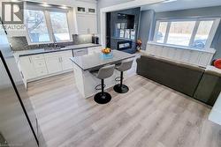 Kitchen with a breakfast bar, a center island, appliances with stainless steel finishes, open floor plan, and white cabinets - 