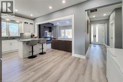 Kitchen with open floor plan, a breakfast bar area, white cabinetry, a center island, and dark stone counters - 