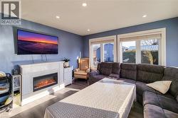 Living area with recessed lighting, wood finished floors, and a glass covered fireplace - 
