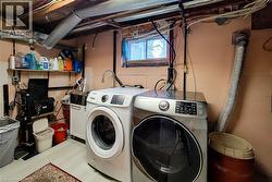 Laundry area with separate washer and dryer and wood finished floors - 