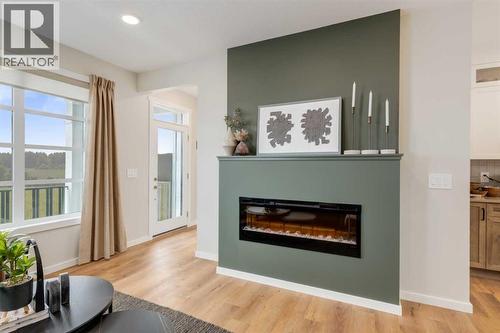 PLEASE NOTE: Photos are of a finished Showhome of the same model – fit and finish may differ on finished spec home. Interior selections and floorplans shown in photos - 154 Bartlett Crescent Se, Calgary, AB - Indoor Photo Showing Living Room With Fireplace