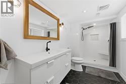 Full bath with vanity, a walk in shower and dark tile patterned floors - 