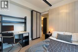 Bedroom with a desk and light wood-style flooring - 