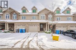 View of front facade featuring an attached garage, stone siding, and covered porch - 