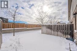 Yard layered in snow with a fenced backyard - 