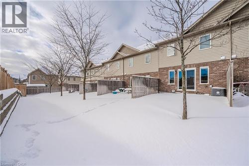 Yard covered in snow featuring a fenced backyard and a residential view - 23 Kingsbury Square Unit# 23, Guelph, ON - Outdoor