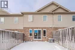Snow covered property with brick siding and a fenced backyard - 