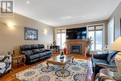 Tall windows flank propane fireplace in livingroo - 