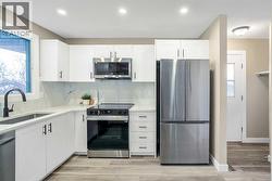 Kitchen has been updated with timeless white shaker cabinets, brand new stainless steel appliances & quartz counters - 
