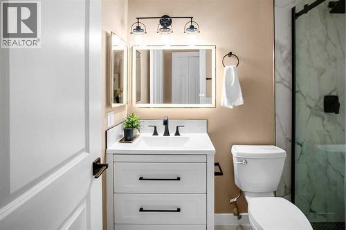 Updated main floor bathroom comes complete with a gorgeous tile surround shower with 10mm glass - 467 Berkley Crescent Nw, Calgary, AB - Indoor Photo Showing Bathroom