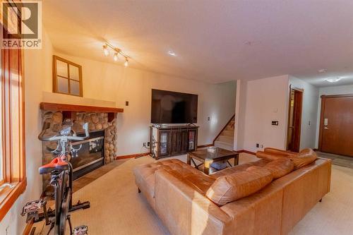 313, 170 Crossbow Place, Canmore, AB - Indoor Photo Showing Living Room With Fireplace