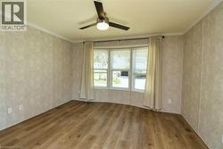 Empty room with hardwood / wood-style floors, crown molding, and a ceiling fan - 