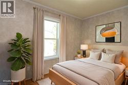 Bedroom featuring ornamental molding and wood finished floors - 