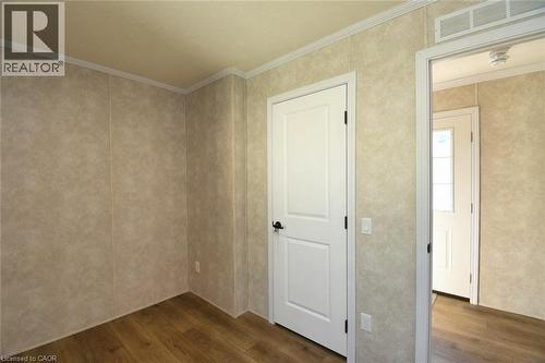 Spare room featuring dark wood-type flooring and ornamental molding - 1085 Concession 10 Road W Unit# 23, Flamborough, ON - Indoor Photo Showing Other Room
