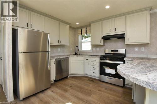 Kitchen featuring appliances with stainless steel finishes, light countertops, dark wood-style floors, under cabinet range hood, and recessed lighting - 1085 Concession 10 Road W Unit# 23, Flamborough, ON - Indoor Photo Showing Kitchen